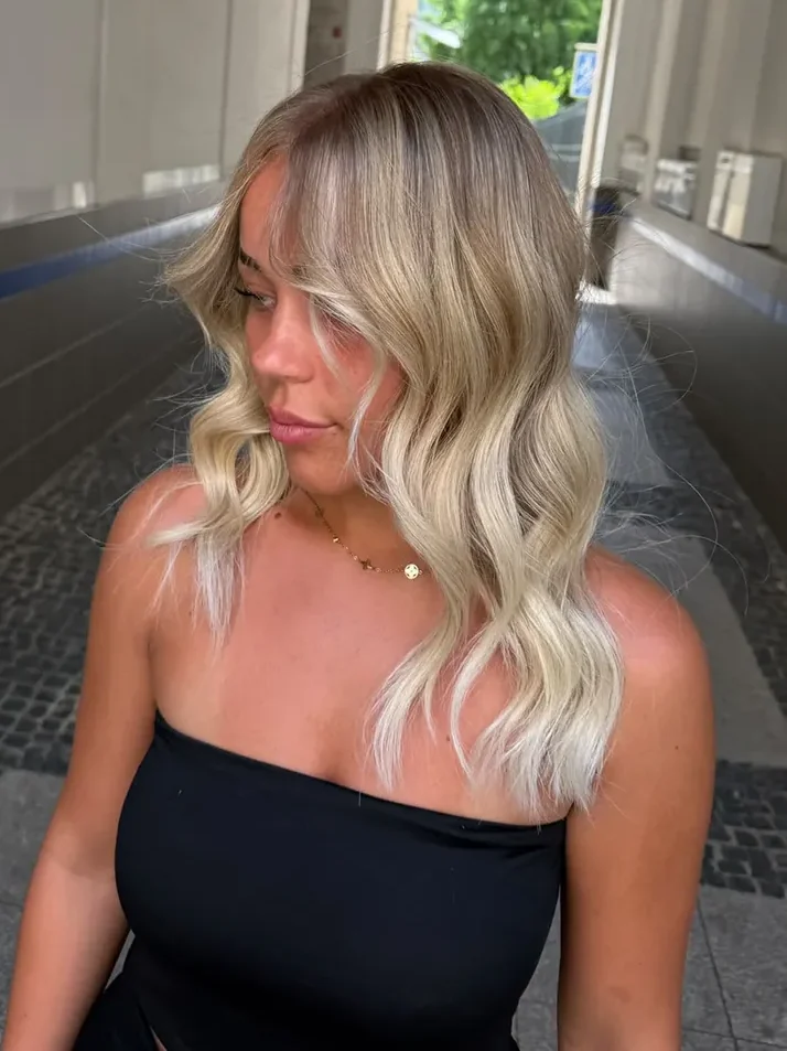 Blonde Balayage mit Shadow Root, Curtain Bangs und Wellen bei Haarstudio No. 8